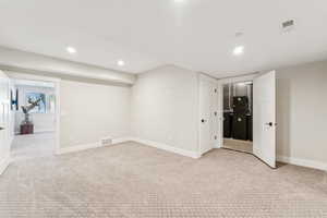 Below grade area featuring light colored carpet and recessed lighting