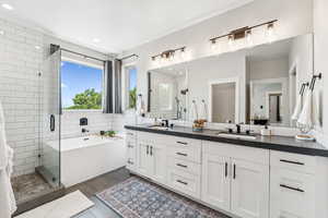 Bathroom featuring a shower stall, double vanity, a garden tub, and recessed lighting