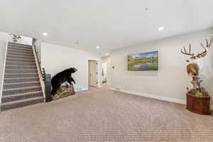 Basement with carpet flooring, stairs, and recessed lighting