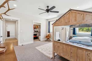 Carpeted bedroom featuring a spacious closet, recessed lighting, and ceiling fan