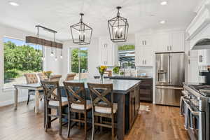 Kitchen with recessed lighting, high quality appliances, decorative backsplash, a center island, and a breakfast bar area