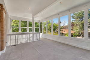 Unfurnished sunroom with healthy amount of natural light, carpet flooring, and recessed lighting