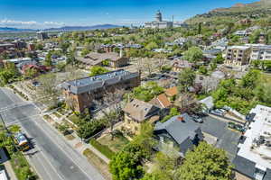 Aerial view of property and surrounding area featuring a mountainous background and nearby suburban area