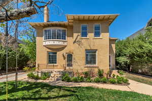 View of front of house featuring a chimney, brick siding, and a front lawn