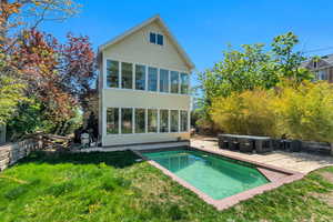 Back of house with a sunroom, a patio area, and a yard