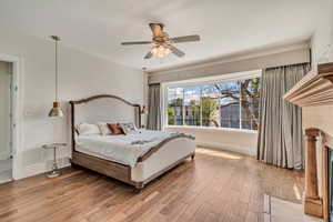 Bedroom featuring wood finished floors, baseboards, and a ceiling fan