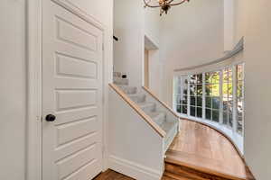 Staircase with a chandelier and wood finished floors