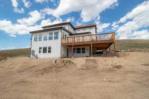 Rear view of house with a deck and driveway