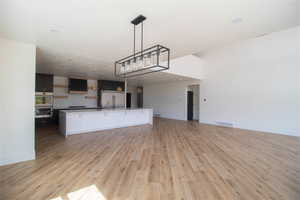 Kitchen with open floor plan, light wood-style flooring, baseboards, and light countertops