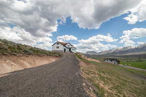 View of dirt / gravel driveway featuring a mountain view and a view of rural / pastoral area