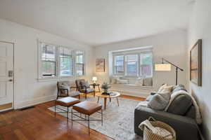 Living room featuring healthy amount of natural light, wood-type flooring, and baseboards