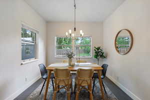 Dining space featuring healthy amount of natural light, a chandelier, and baseboards