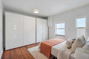 Bedroom with dark wood-style flooring