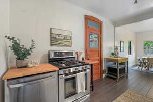 Kitchen with stainless steel appliances, wood counters, and ornamental molding
