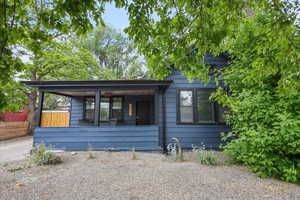 View of front of home with covered porch and fence