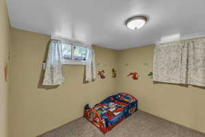 Bedroom featuring carpet and baseboards