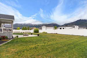 View of yard with a mountain view, a patio area, and a fire pit