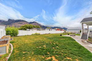 View of yard with an outdoor fire pit, a patio, a mountain view, and a garden