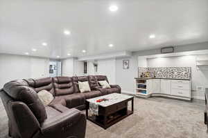 Living area with a bar, recessed lighting, and baseboards