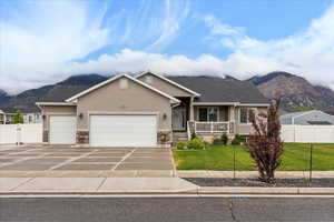 View of front of home featuring stucco siding, a mountain view, stone siding, and a garage