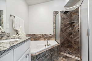 Full bath with a stall shower, a tub with jets, marble look tile flooring, and vanity