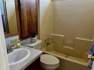 Bathroom with toilet, vanity, and bathtub / shower combination