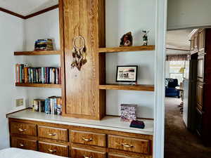 Detailed view of a textured ceiling, carpet flooring, and crown molding