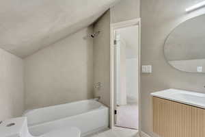 Full bath featuring toilet, vaulted ceiling, bathtub / shower combination, and vanity