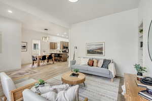 Living room with light wood-style floors, recessed lighting, built in features, and baseboards