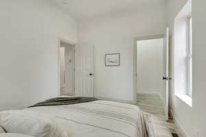 Bedroom with light wood-style flooring and baseboards
