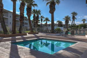 View of pool with a patio area, fence, and a residential view