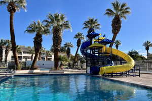 Community pool with fence and a water slide