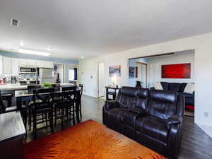 Living room with dark wood finished floors and recessed lighting