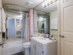 Bathroom with toilet, vanity, and shower / tub combo