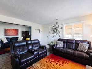 Living area featuring wood finished floors and a textured ceiling