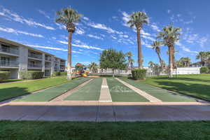 View of home's community with a yard and shuffleboard
