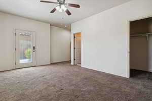 Unfurnished bedroom with carpet flooring, a walk in closet, baseboards, a ceiling fan, and a closet