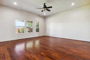 Empty room featuring hardwood / wood-style flooring, a ceiling fan, recessed lighting, and baseboards