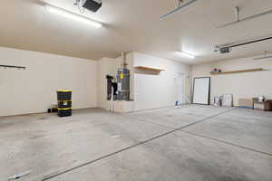 Garage featuring secured water heater and a garage door opener