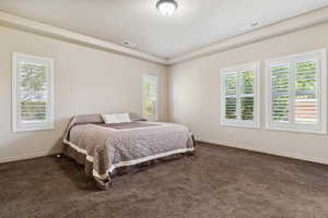 Bedroom with dark carpet and baseboards