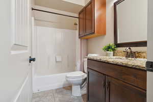 Full bathroom featuring vanity, toilet, shower / tub combination, and tile patterned floors