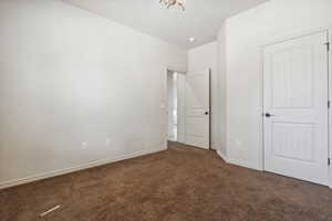 Unfurnished bedroom featuring carpet floors and baseboards
