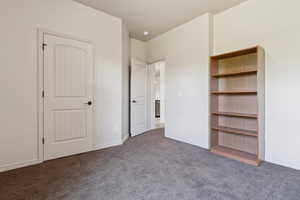Unfurnished bedroom with carpet flooring and baseboards