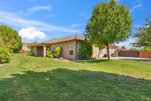 Back of house featuring stucco siding, a gate, and a tiled roof