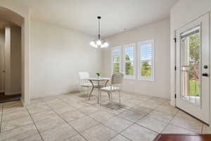 Dining area with healthy amount of natural light, arched walkways, light tile patterned floors, and baseboards