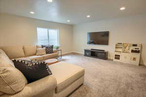 Carpeted living room featuring recessed lighting and baseboards