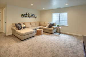 Living area with carpet, baseboards, and recessed lighting