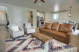 Living area featuring ceiling fan, light wood-style floors, and recessed lighting