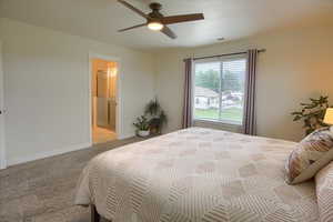 Bedroom featuring light carpet, baseboards, a ceiling fan, and connected bathroom