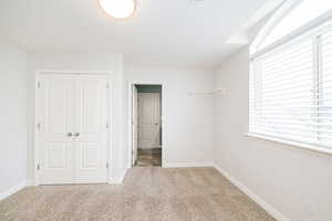 Unfurnished bedroom featuring carpet flooring, a closet, and baseboards